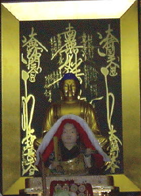 The Gohonzon representing the Three Jewels of the Dharma [Mandala], the Buddha and Nichiren [representing the Sangha]